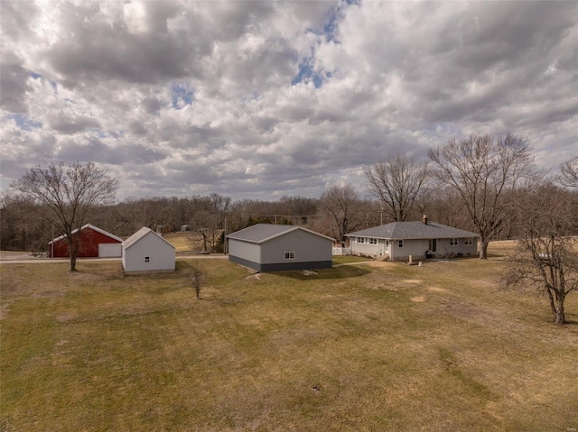 view of grassy yard with an outdoor structure and an outbuilding
