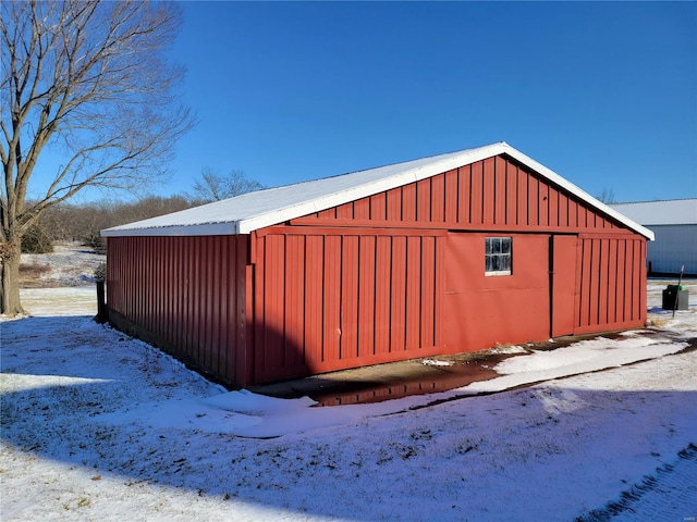snow covered structure featuring an outbuilding