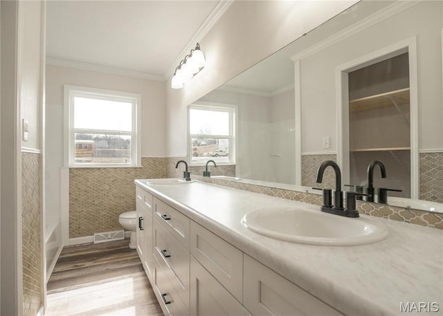 514 W Missouri St, Bloomfield, MO 63825 - bathroom with wainscoting, tile walls, double vanity, toilet, and wood finished floors