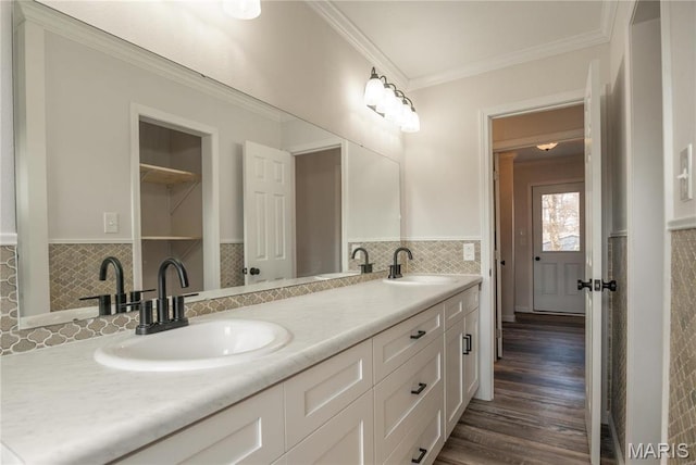 514 W Missouri St, Bloomfield, MO 63825 - bathroom featuring tile walls, ornamental molding, wood finished floors, double vanity, and a wainscoted wall