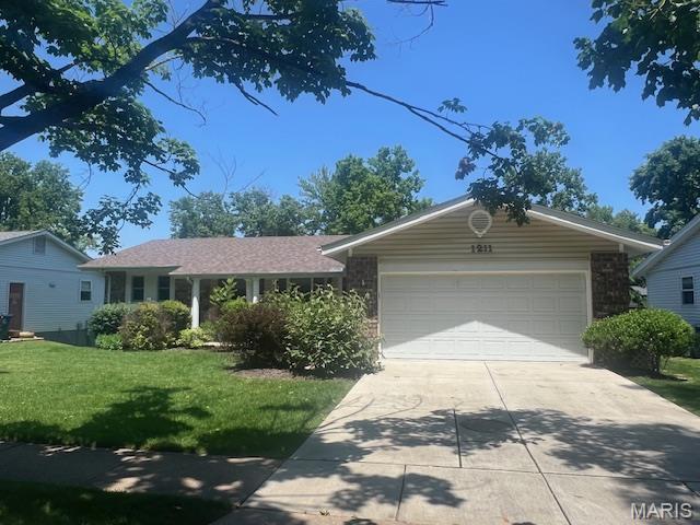 1211 Dorne Dr, Manchester, MO 63021 - ranch-style home with driveway, a front yard, an attached garage, and stone siding