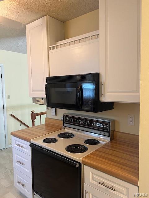 1211 Dorne Dr, Manchester, MO 63021 - kitchen featuring white electric range, black microwave, white cabinets, a textured ceiling, and wooden counters