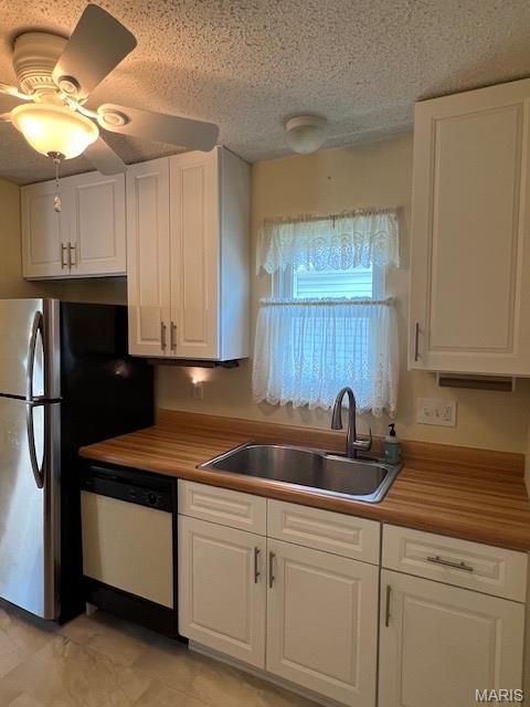 1211 Dorne Dr, Manchester, MO 63021 - kitchen with white dishwasher, white cabinets, a textured ceiling, and freestanding refrigerator