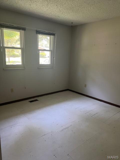 1211 Dorne Dr, Manchester, MO 63021 - spare room with a textured ceiling and baseboards