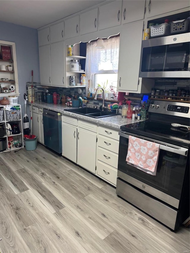 kitchen featuring stainless steel appliances, a sink, light wood-style floors, and light countertops