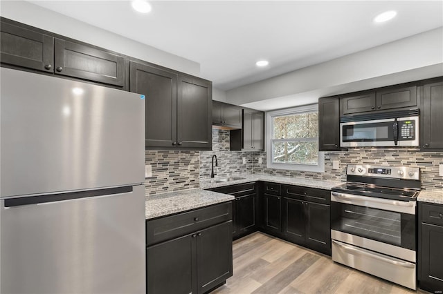 1686 Mowbry Ln, Saint Louis, MO 63136 - kitchen with stainless steel appliances, a sink, light stone counters, tasteful backsplash, and recessed lighting