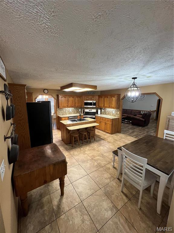 dining area featuring a textured ceiling and light tile patterned floors
