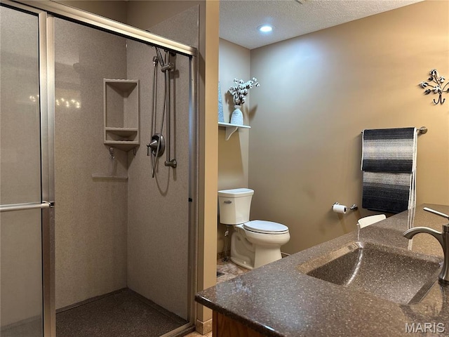 full bathroom with a stall shower, toilet, vanity, and a textured ceiling