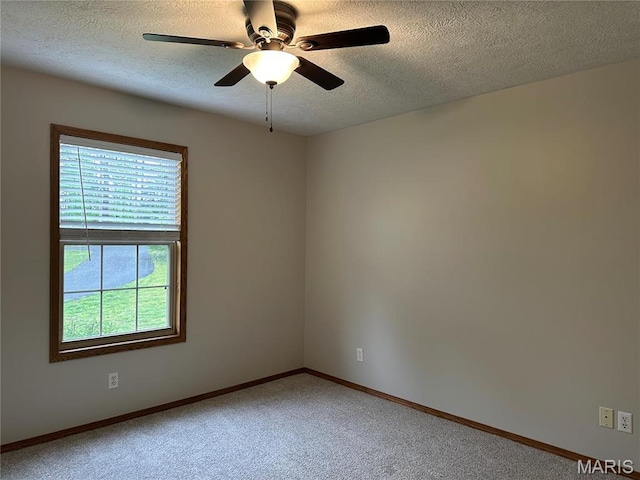unfurnished room featuring light colored carpet, a textured ceiling, ceiling fan, and baseboards