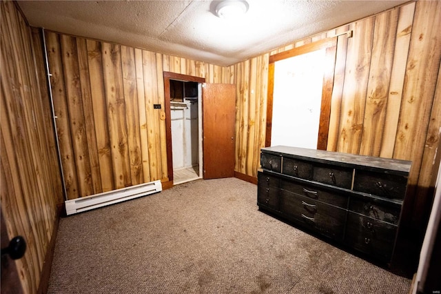 1407 N 435th St Unit 1 & 2, Vandalia, IL 62471 - unfurnished bedroom with a baseboard heating unit, carpet, wood walls, a closet, and a textured ceiling