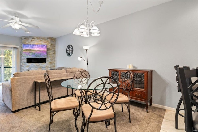 dining room with ceiling fan, light carpet, a chandelier, and baseboards