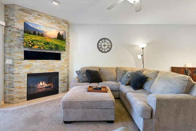 living area featuring a fireplace, a ceiling fan, carpet flooring, and tile patterned floors