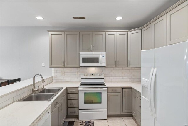 kitchen with white appliances, a sink, gray cabinets, decorative backsplash, and recessed lighting