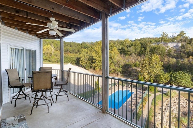 balcony featuring a ceiling fan and a view of trees