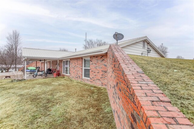 302 E Bay St, Pleasant Hill, IL 62366 - view of side of home with a patio area, a lawn, brick siding, and metal roof