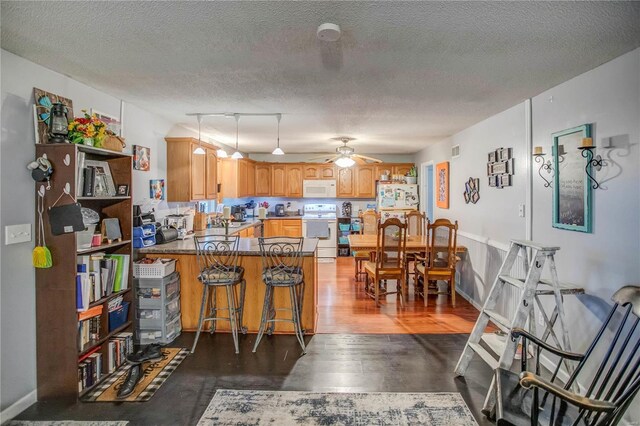302 E Bay St, Pleasant Hill, IL 62366 - kitchen with range, white microwave, a peninsula, a ceiling fan, and a textured ceiling