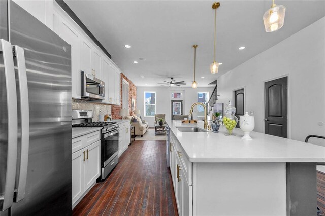 3330 Iowa Ave, Saint Louis, MO 63118 - kitchen featuring stainless steel appliances, a sink, recessed lighting, white cabinets, and a center island with sink