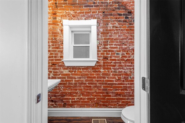 3330 Iowa Ave, Saint Louis, MO 63118 - bathroom with brick wall, wood finished floors, and toilet