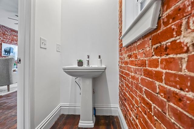 3330 Iowa Ave, Saint Louis, MO 63118 - bathroom featuring brick wall, hardwood / wood-style floors, baseboards, and a sink