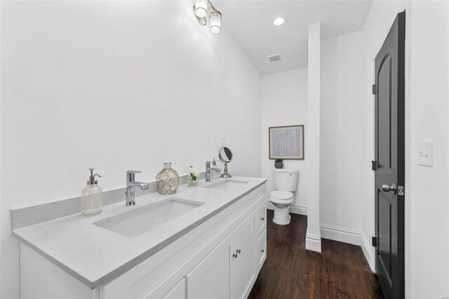3330 Iowa Ave, Saint Louis, MO 63118 - bathroom with toilet, double vanity, wood finished floors, baseboards, and recessed lighting