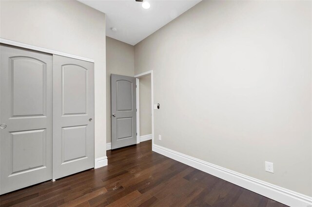 3330 Iowa Ave, Saint Louis, MO 63118 - unfurnished bedroom featuring dark wood-style flooring, baseboards, and a closet
