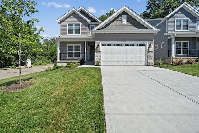 craftsman-style house with a front yard, driveway, a garage, stone siding, and a porch