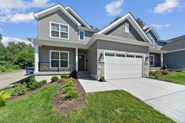 craftsman house featuring covered porch, an attached garage, concrete driveway, stone siding, and a front yard