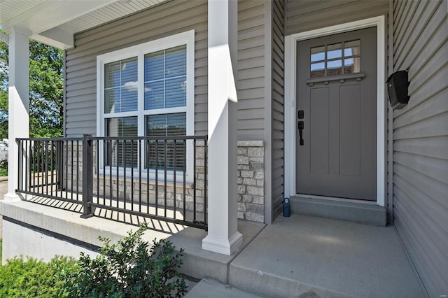 property entrance with covered porch and stone siding
