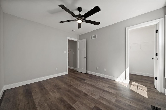 unfurnished bedroom featuring dark wood-style floors, baseboards, a ceiling fan, and a closet