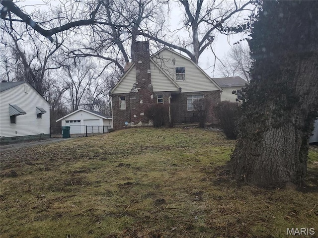 45 Jarvis Pl, Cahokia, IL 62207 - rear view of house with a detached garage, brick siding, a chimney, and an outbuilding