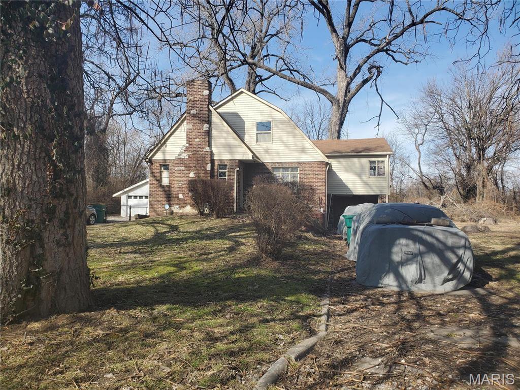 45 Jarvis Pl, Cahokia, IL 62207 - view of side of home featuring brick siding, a chimney, and a yard