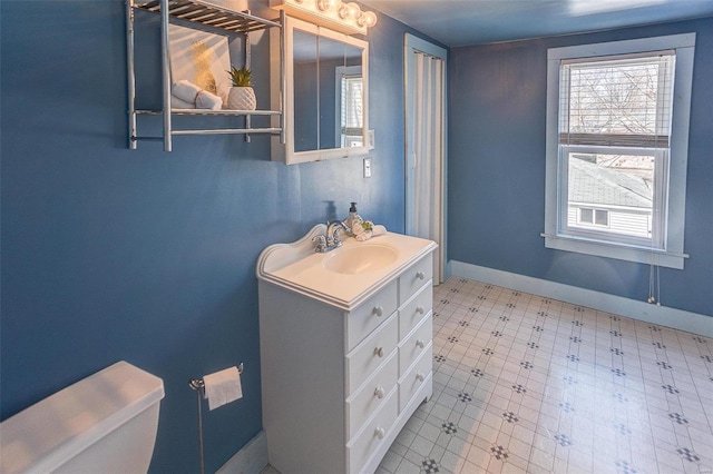 bathroom with tile patterned floors, baseboards, toilet, and vanity