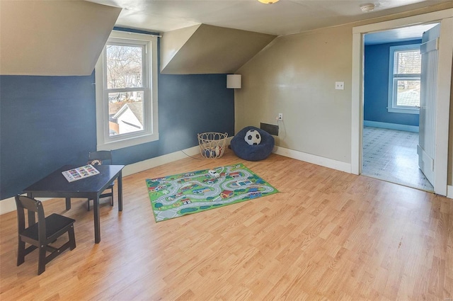 playroom with lofted ceiling, wood finished floors, plenty of natural light, and baseboards
