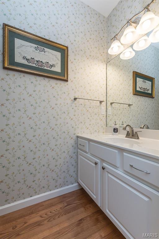885 Morgan Rdg, High Ridge, MO 63049 - bathroom with wood finished floors, vanity, and wallpapered walls