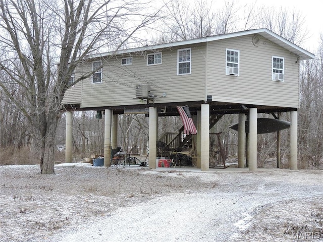 17 Martone St, Elsberry, MO 63343 - snow covered back of property with a carport, cooling unit, stairs, and driveway