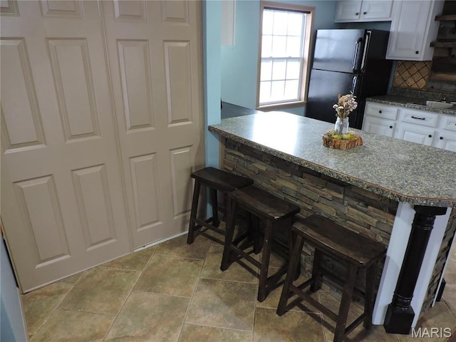 17 Martone St, Elsberry, MO 63343 - kitchen featuring freestanding refrigerator, a breakfast bar area, and white cabinetry
