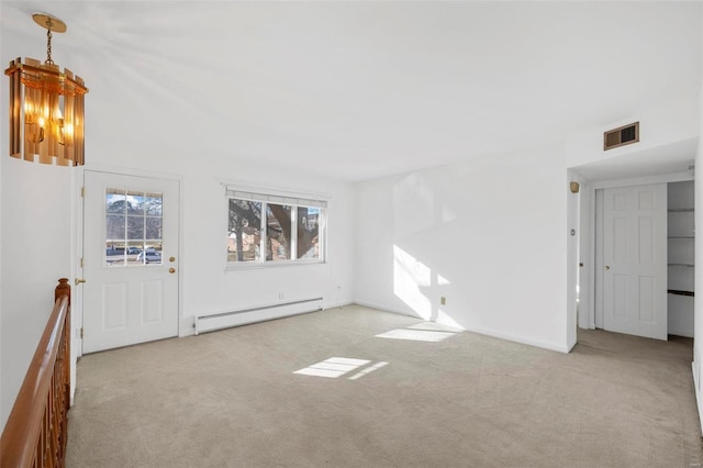 unfurnished living room featuring a baseboard heating unit and carpet floors
