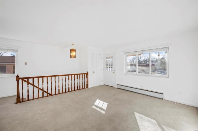 spare room featuring a baseboard radiator, carpet, and a chandelier