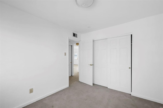 unfurnished bedroom with carpet, a closet, and baseboards