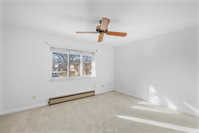 empty room with a baseboard heating unit, carpet, a ceiling fan, and baseboards
