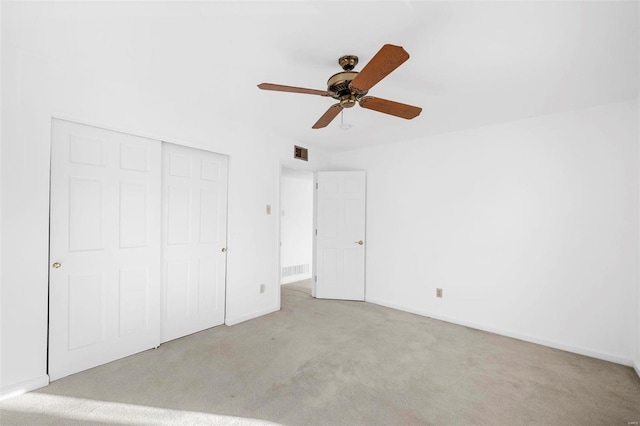 unfurnished bedroom with carpet, a closet, baseboards, and a ceiling fan