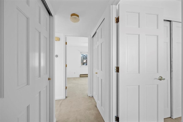 hall with light carpet, baseboards, and baseboard heating