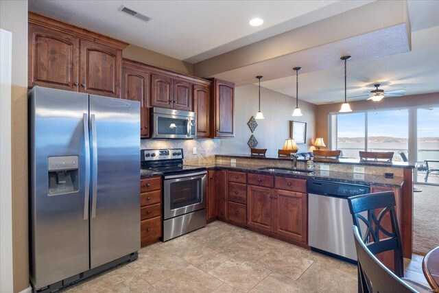 18051 Blue Anchor Dr Unit 522, Gravois Mills, MO 65037 - kitchen featuring stainless steel appliances, a sink, a peninsula, pendant lighting, and decorative backsplash