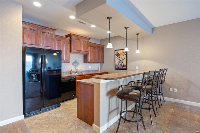18051 Blue Anchor Dr Unit 522, Gravois Mills, MO 65037 - kitchen featuring black appliances, a peninsula, a kitchen bar, pendant lighting, and a sink