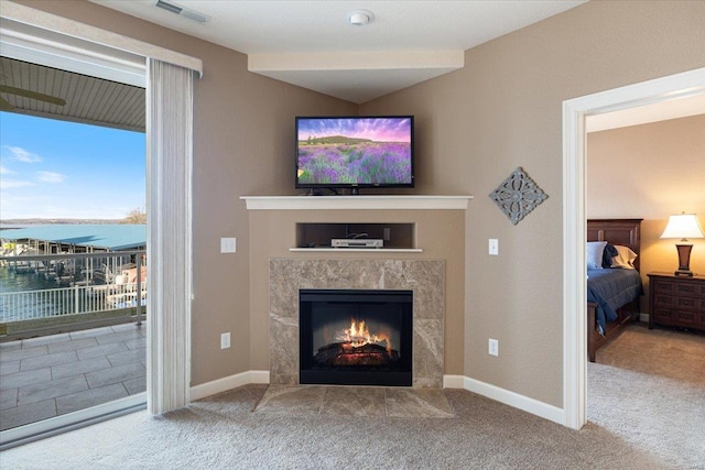 18051 Blue Anchor Dr Unit 522, Gravois Mills, MO 65037 - carpeted living room featuring a premium fireplace, baseboards, and a water view