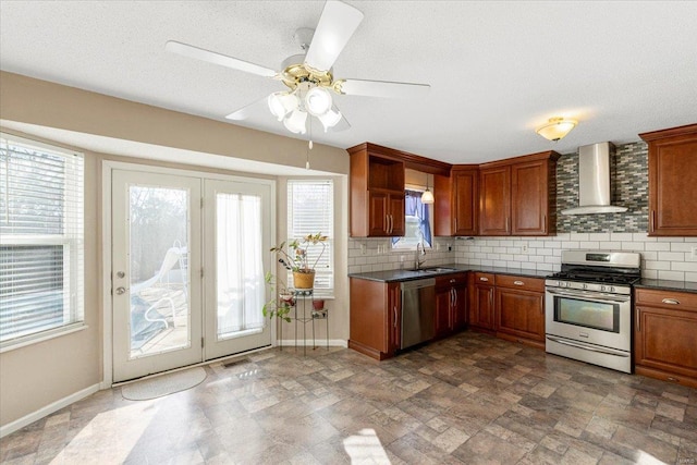 2537 Castle Pines Dr, Imperial, MO 63052 - kitchen featuring appliances with stainless steel finishes, wall chimney range hood, dark countertops, and decorative backsplash