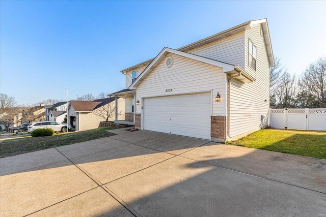 2537 Castle Pines Dr, Imperial, MO 63052 - view of property exterior featuring concrete driveway, a garage, and fence