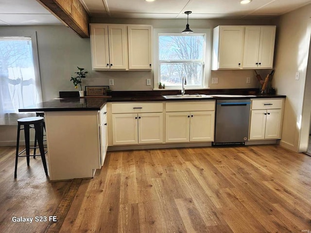 972 Sunny Ridge Vw, Union, MO 63084 - kitchen featuring dishwasher, a peninsula, a sink, dark countertops, and light wood-style floors