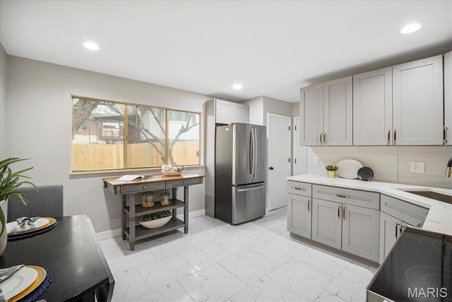 4501 Conleth Dr, Saint Louis, MO 63129 - kitchen with freestanding refrigerator, light marble finish flooring, gray cabinets, a sink, and baseboards