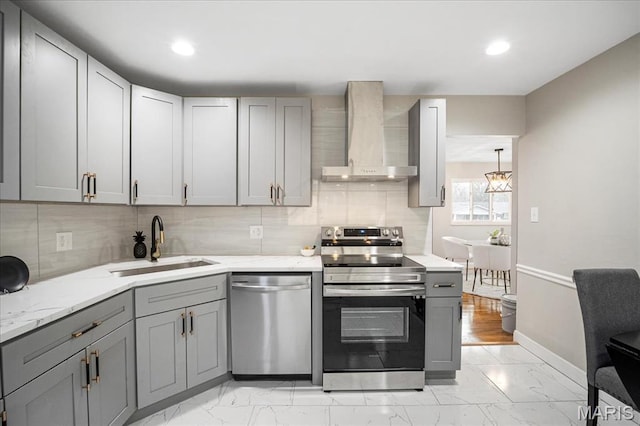 4501 Conleth Dr, Saint Louis, MO 63129 - kitchen featuring appliances with stainless steel finishes, wall chimney range hood, gray cabinets, a sink, and light marble finish floors